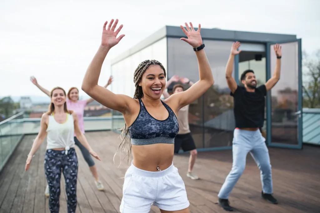 Group of young people doing exercise outdoors on terrace, sport and healthy lifestyle concept